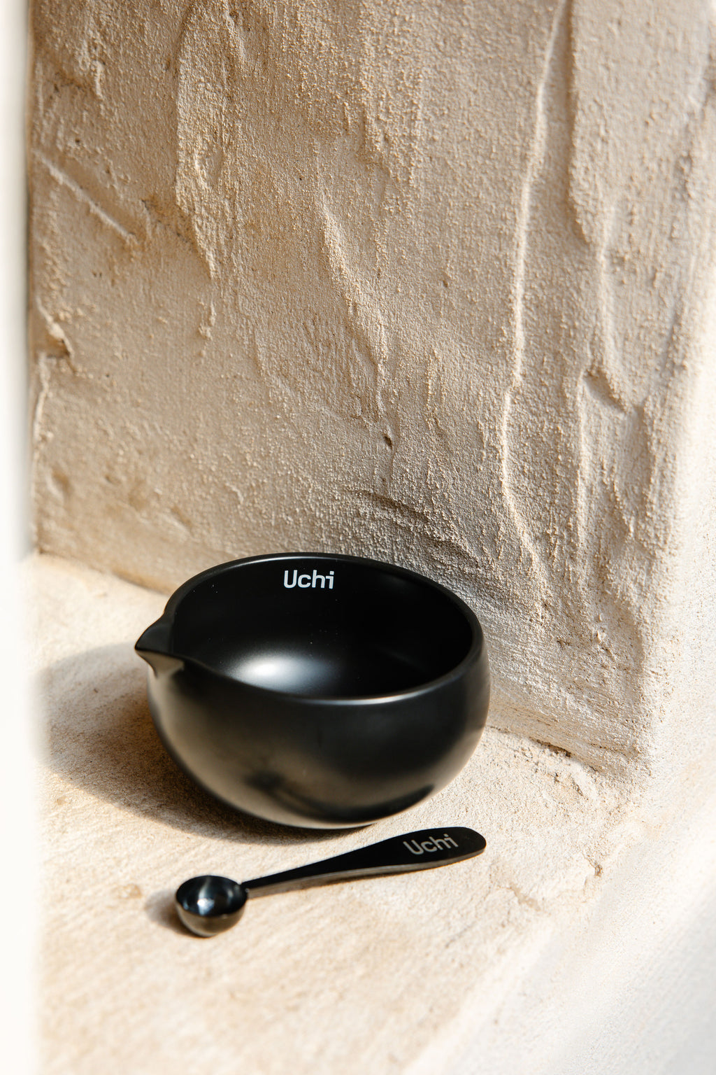 Uchi Bowl, ceramic matcha bowl in matte black, with matcha spoon next to it