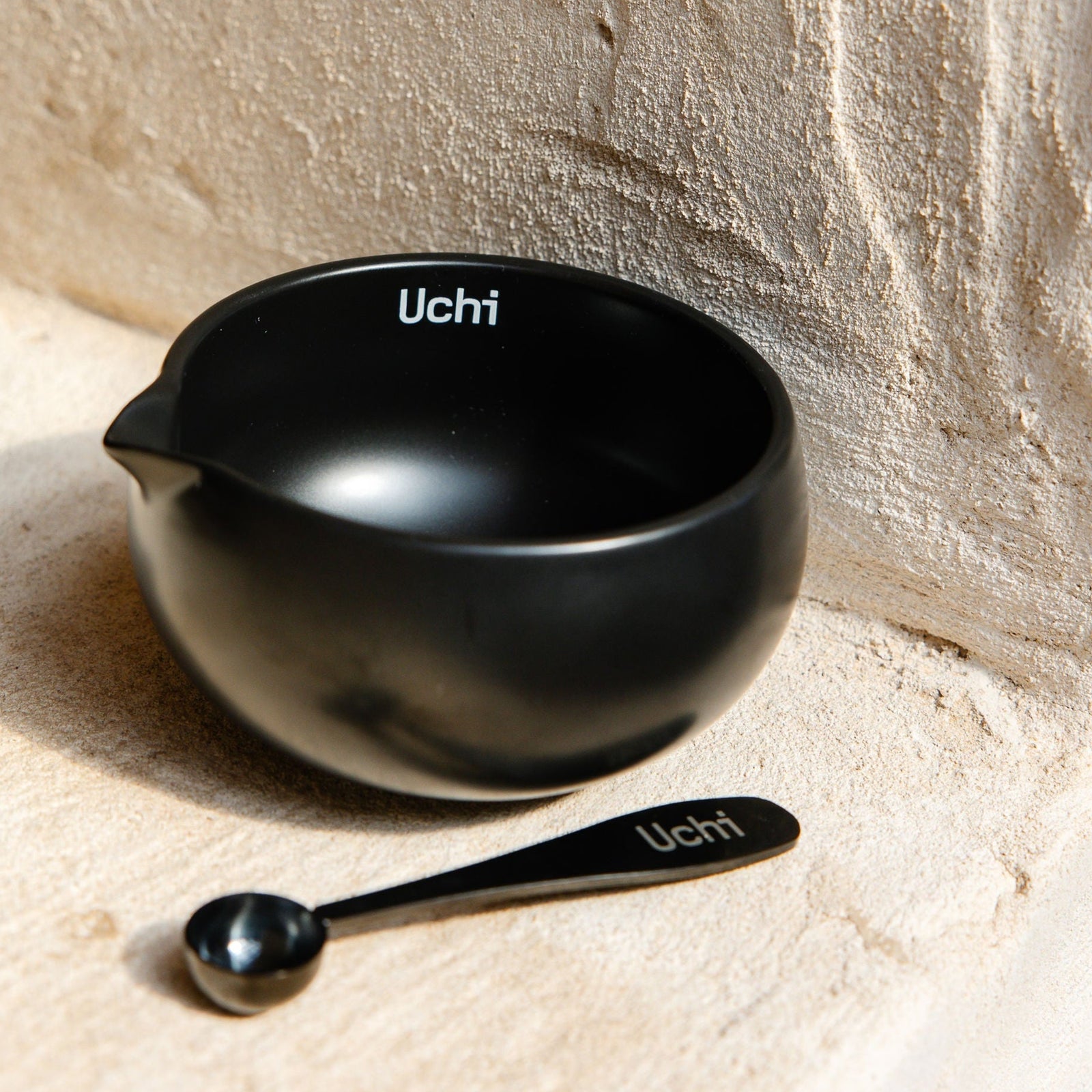 Uchi Bowl, ceramic matcha bowl in matte black, with matcha spoon next to it