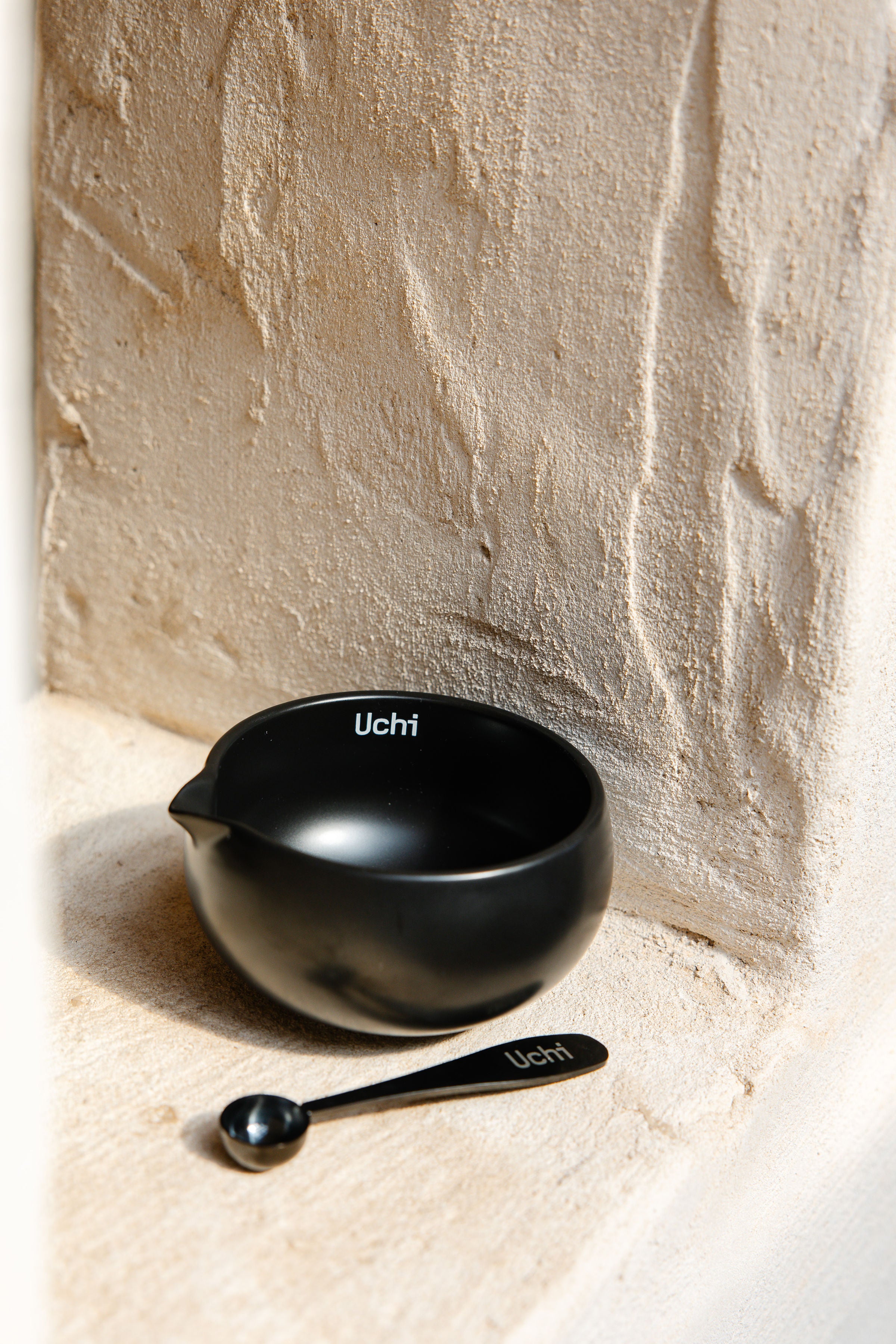 Uchi Bowl, ceramic matcha bowl in matte black, with matcha spoon next to it