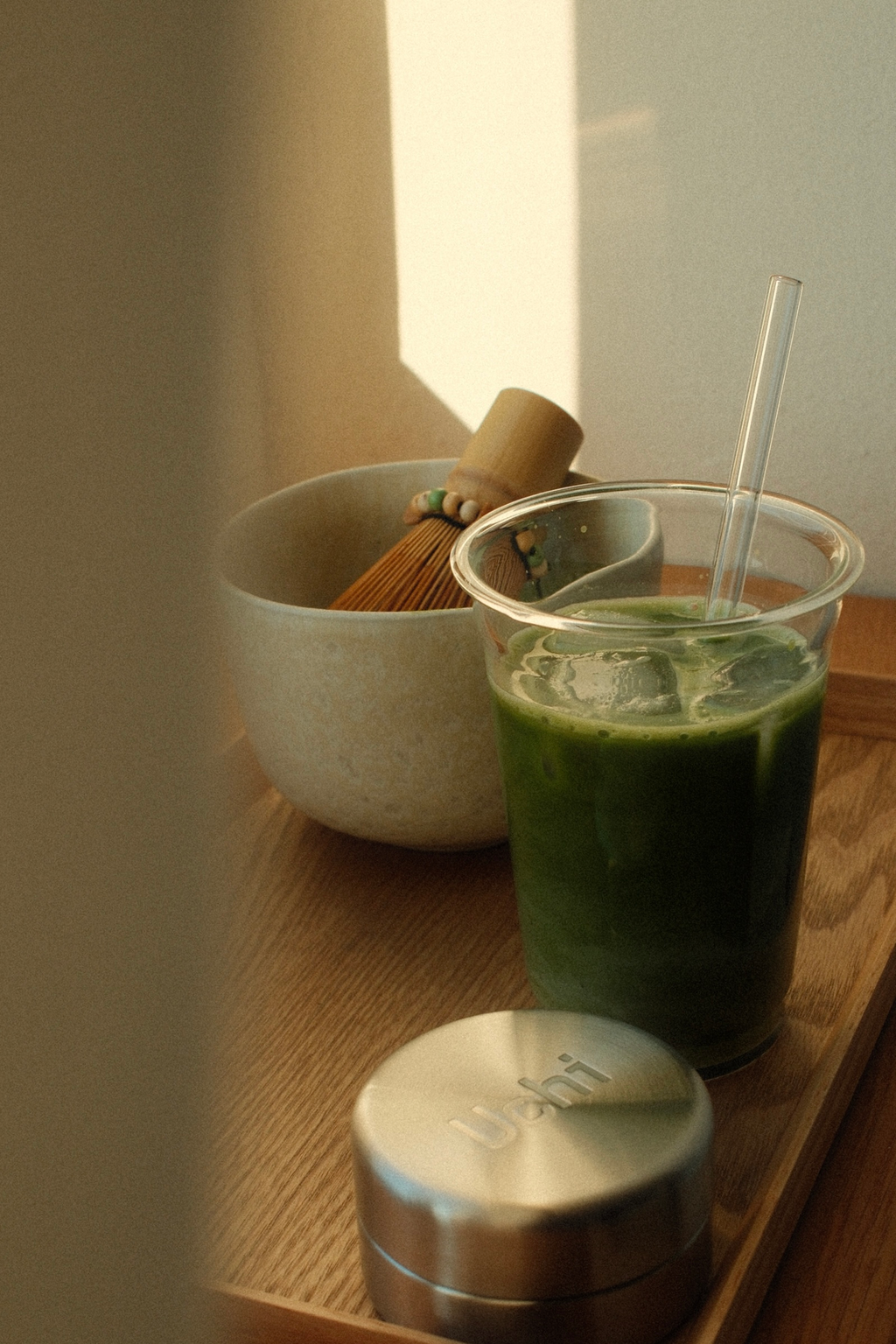 Uchi matcha system in a home setting, steel matcha canister, design matcha for in kitchen. Iced matcha latte on the table