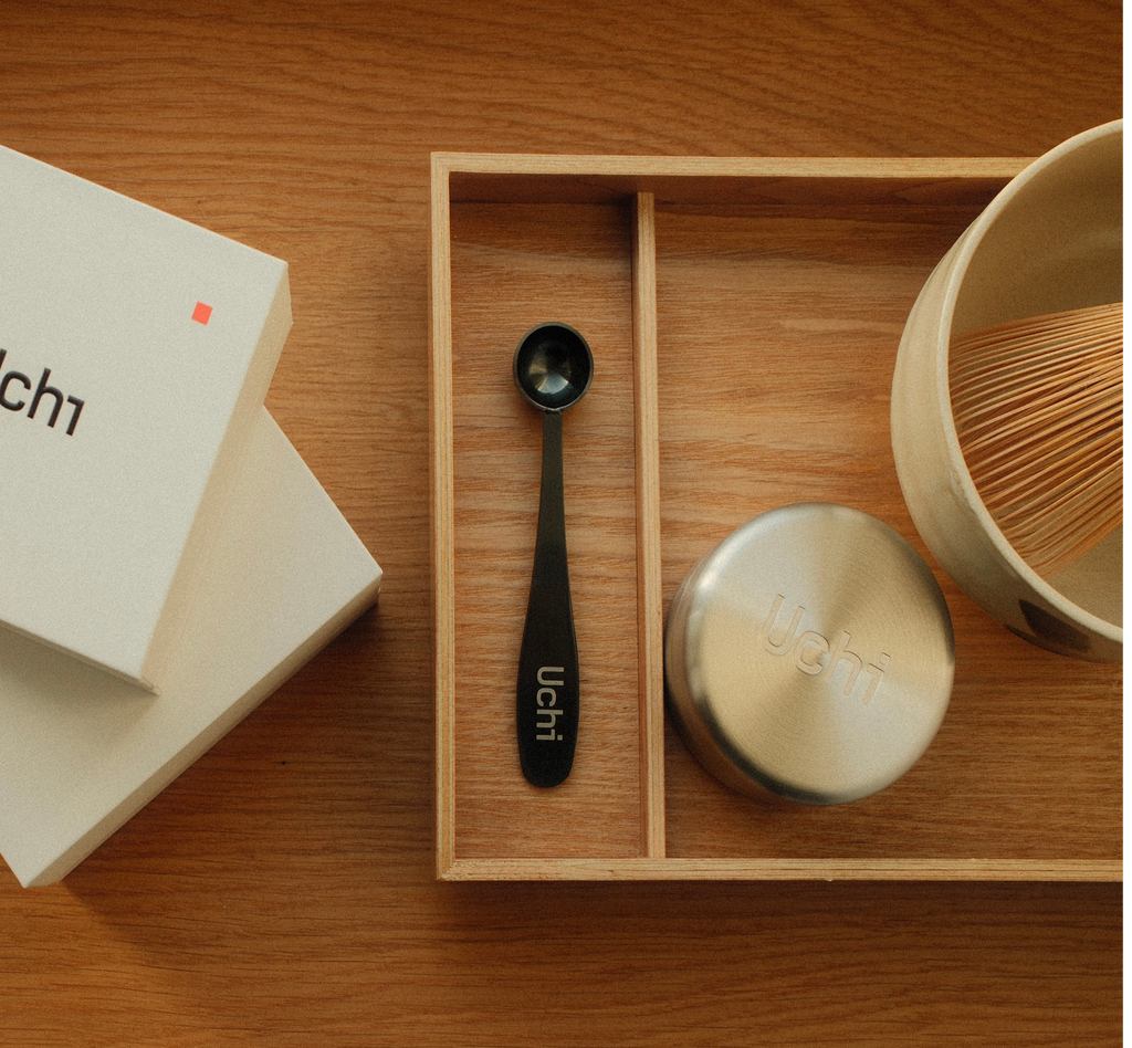 Uchi tea set with a spoon and matcha canister on a wooden surface, making matcha