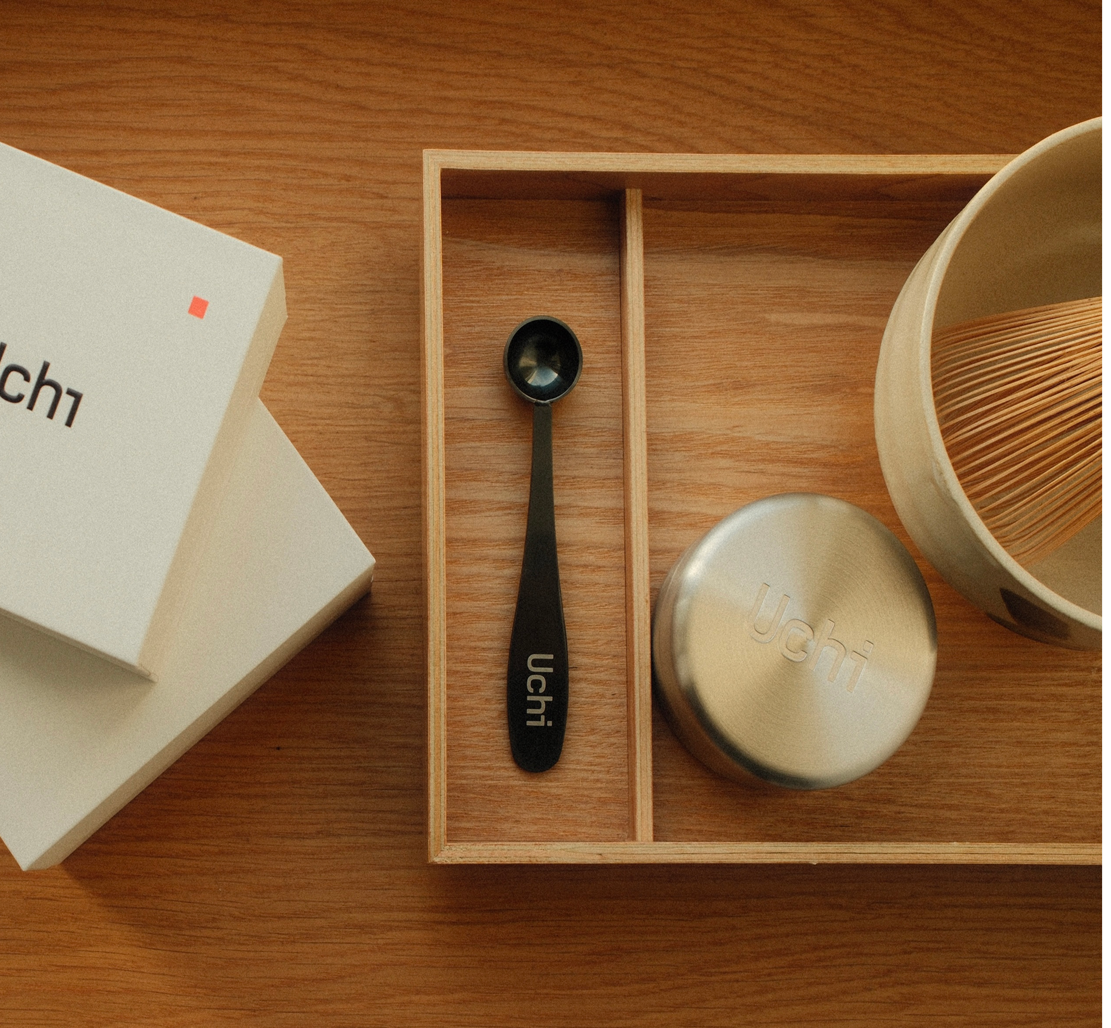 Uchi tea set with a spoon and matcha canister on a wooden surface, making matcha