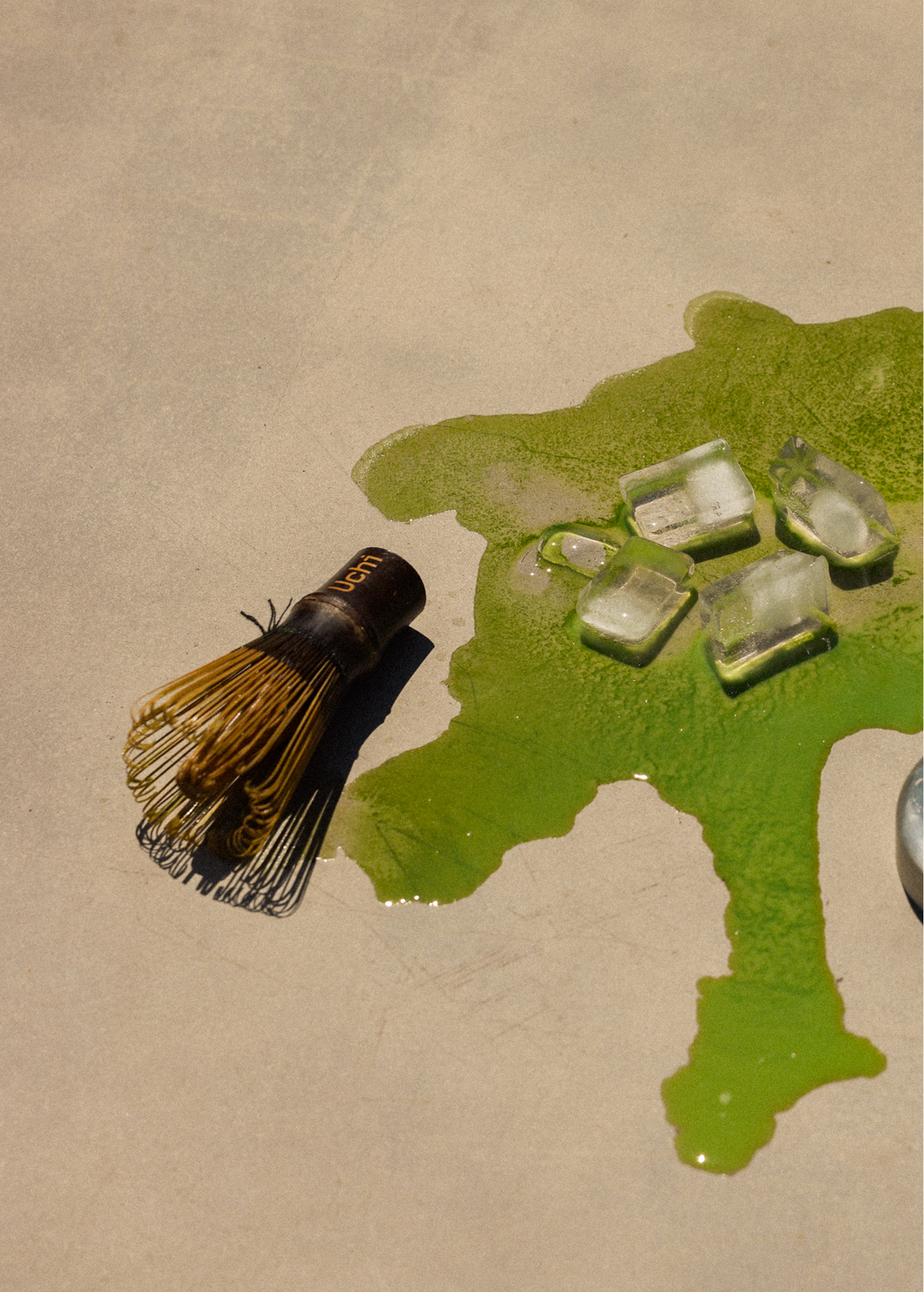 Uchi Whisk next to spilled iced matcha